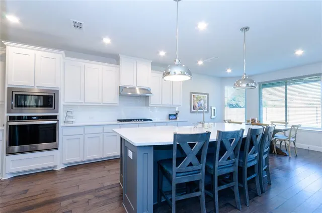 a large kitchen with kitchen island a dining table and chairs