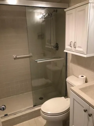 a bathroom with a shower a toilet and a sink