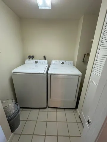 an empty room with windows and chandelier fan
