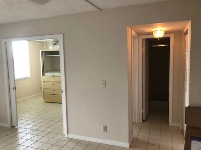 a view of a hallway with wooden floor and a bathroom