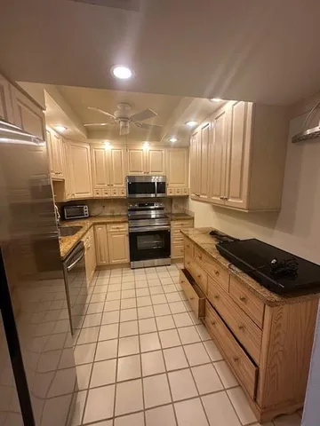 a kitchen with granite countertop a stove sink and cabinets