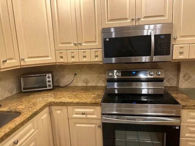 a kitchen with granite countertop a stove and a microwave