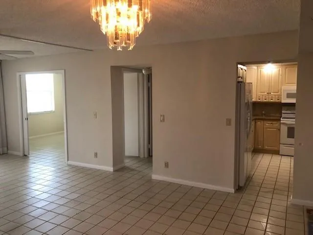 an empty room with kitchen view