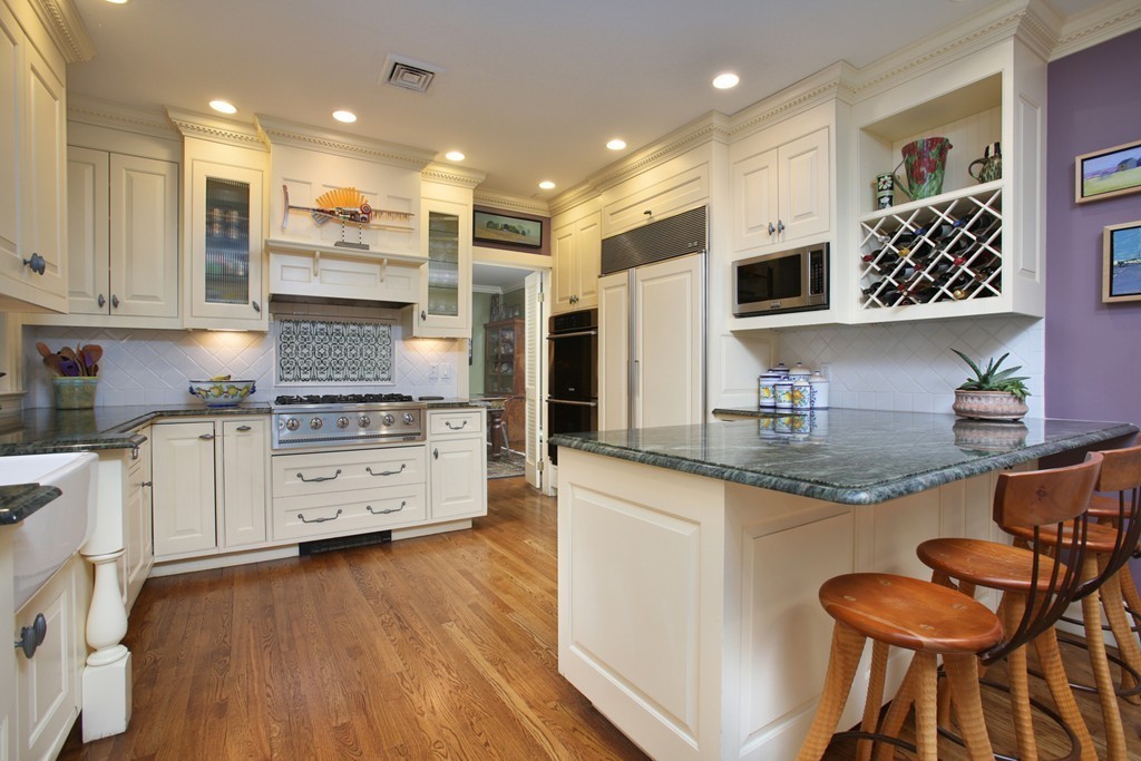 a kitchen with granite countertop white cabinets and appliances