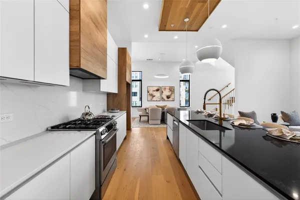 a kitchen with granite countertop a sink a stove and cabinets