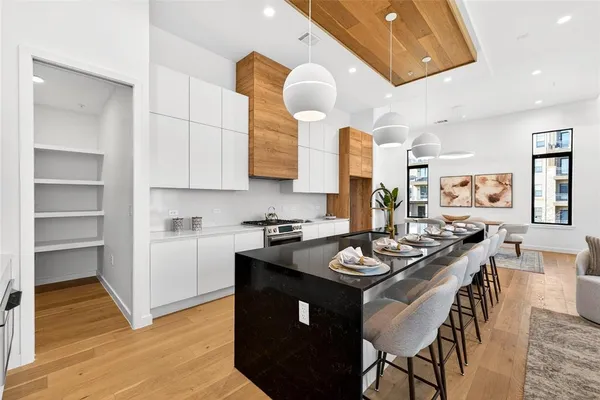 a kitchen with stainless steel appliances granite countertop a stove a sink dishwasher and cabinets with wooden floor