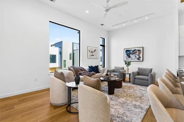 a living room with furniture wooden floor and a large window