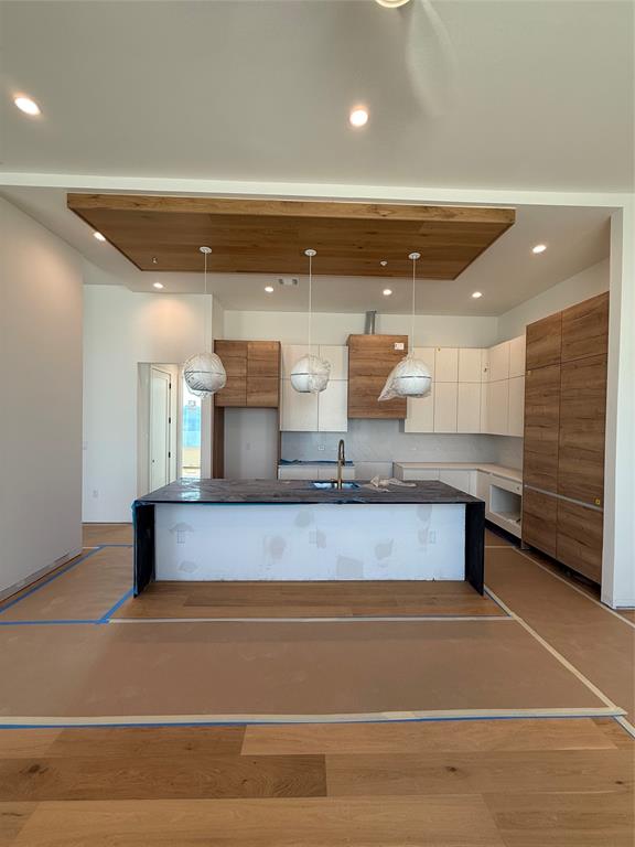 1111 Raiford Road, Unit 105 Carrollton, TX 75007 - Photo 6 of 17 Kitchen with modern cabinets, wood finished floors, a kitchen island with sink, recessed lighting, and dark stone counters