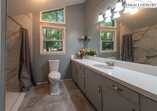 a bathroom with a double vanity sink toilet and a mirror