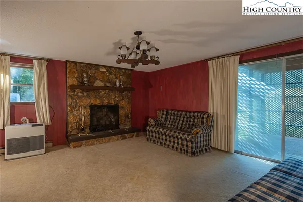 a view of a livingroom with a fireplace and window
