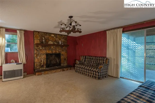 a view of a livingroom with a fireplace and window