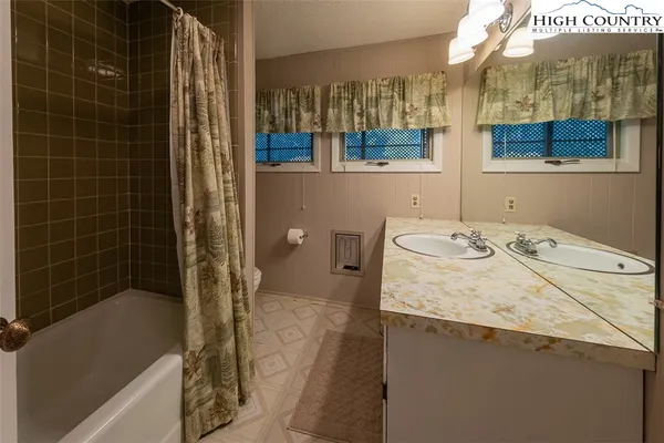 a bathroom with a granite countertop sink a toilet and shower