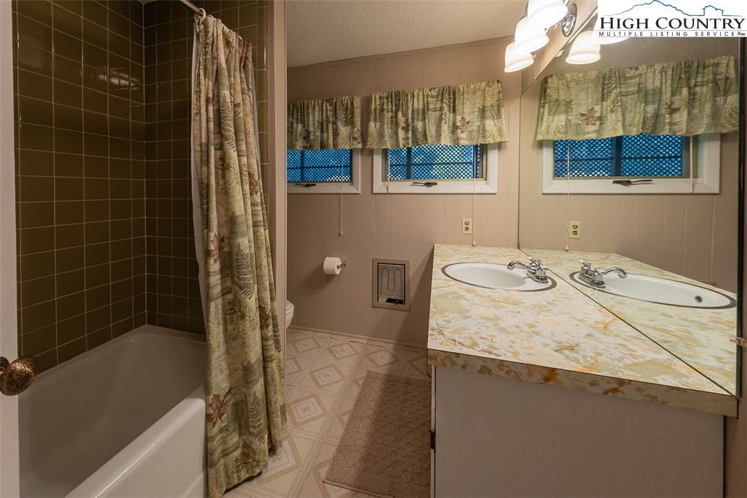 377 Deer Run Road Glade Valley, NC 28627 - Photo 22 of 26 a bathroom with a granite countertop sink a toilet and shower