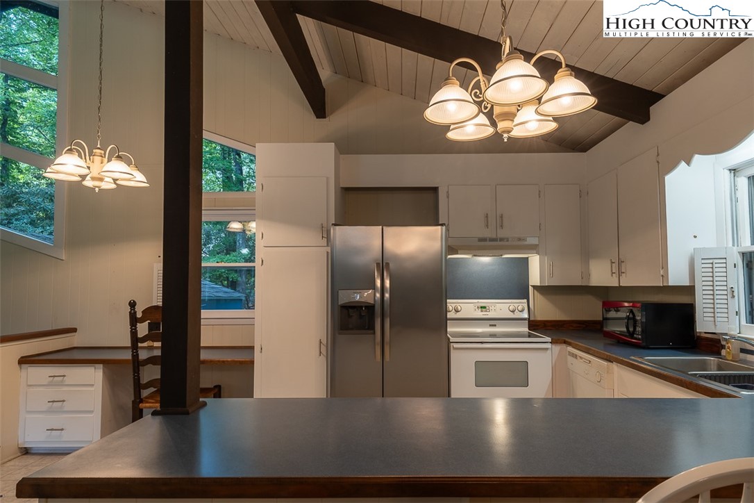 377 Deer Run Road Glade Valley, NC 28627 - Photo 9 of 26 a kitchen with stainless steel appliances a large counter top a stove a chimney a sink and a refrigerator
