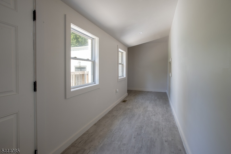 79 Lake Wallkill Road Vernon, NJ 07461 - Photo 14 of 27 a view of an empty room with wooden floor and a window