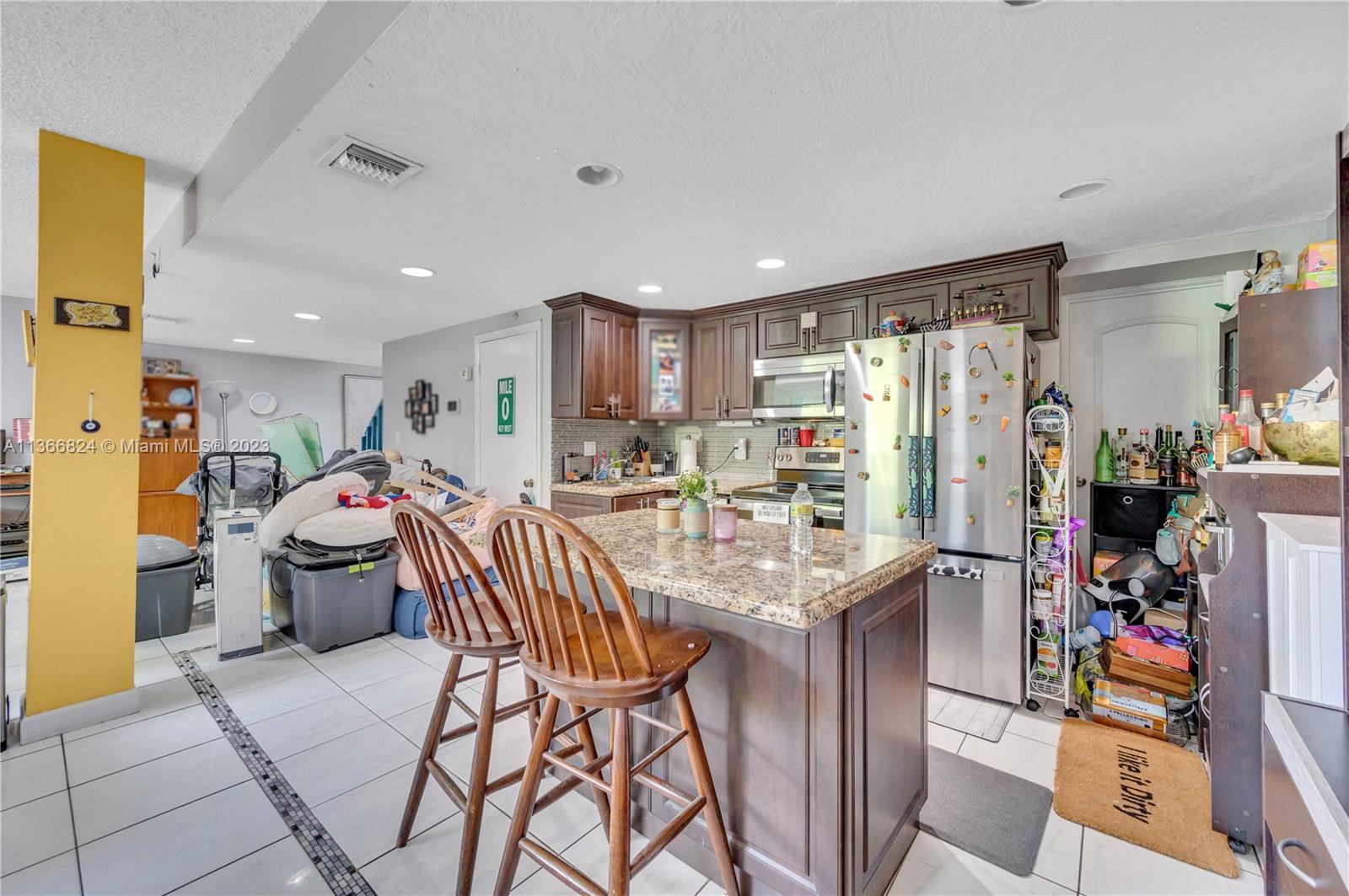 2729 Southwest 67th Avenue Miami, FL 33155 - Photo 25 of 37 a kitchen with stainless steel appliances kitchen island granite countertop a refrigerator and a sink
