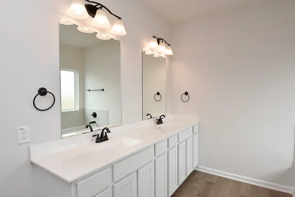 a bathroom with a double vanity sink and a mirror