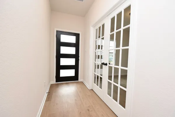a view of a hallway with wooden floor and entryway