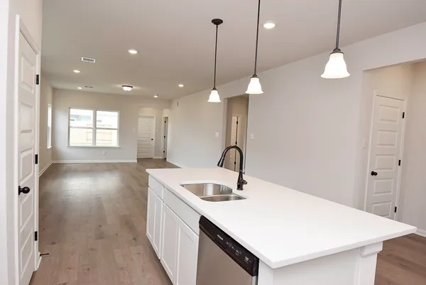 a kitchen with a sink a center island a stove and a chandelier