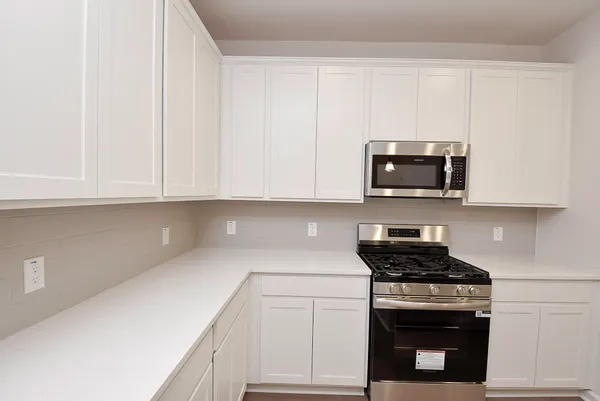 a kitchen with white cabinets and stainless steel appliances