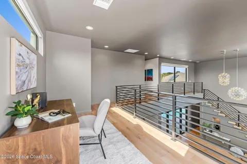 an empty room with wooden floor fan and windows