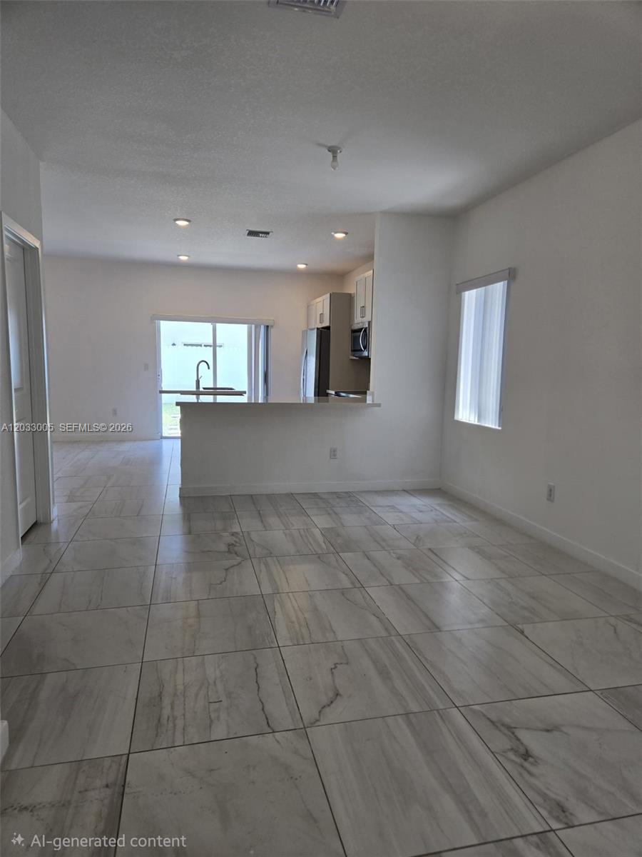 862 Southeast 17 Street, Unit 862 Homestead, FL 33034 - Photo 27 of 39 an empty room with kitchen view and windows