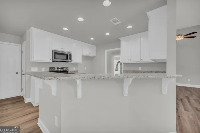 a kitchen with white cabinets and stainless steel appliances