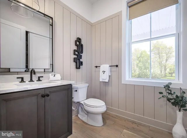 a bathroom with a toilet a sink and a mirror