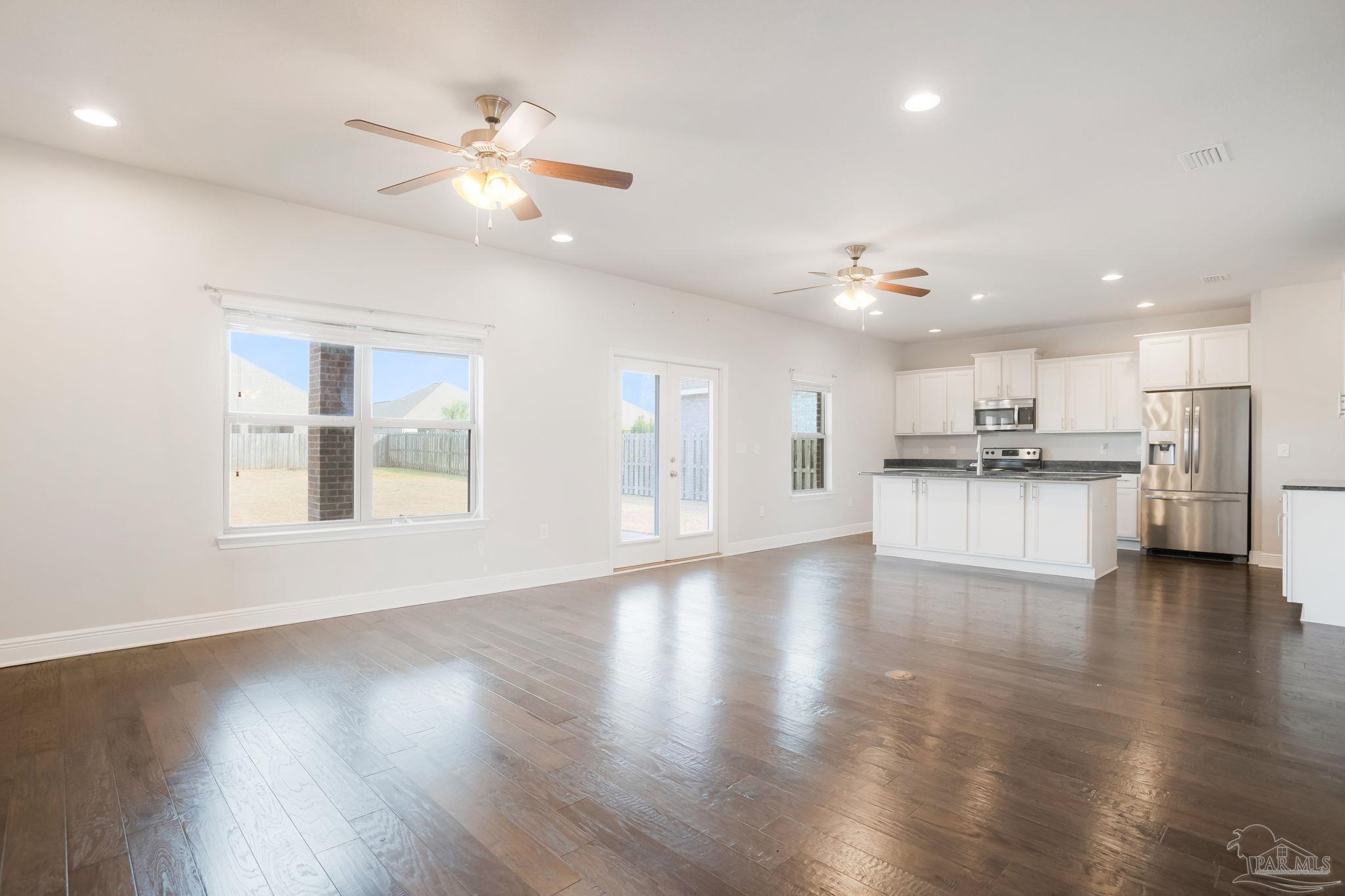 8016 Woodbrook Road Pensacola, FL 32526 - Photo 13 of 52 a view of an empty room and kitchen with wooden floor