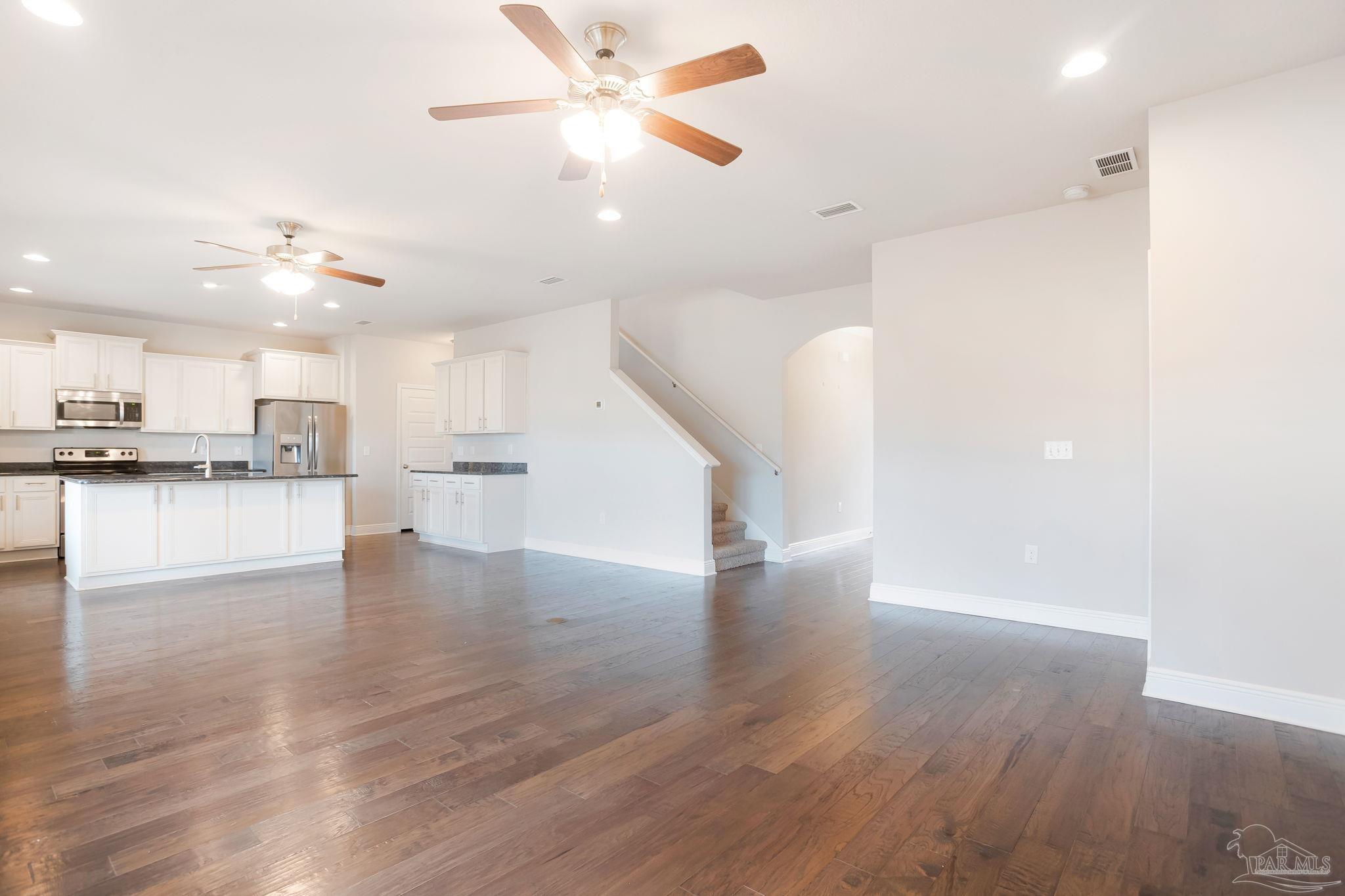8016 Woodbrook Road Pensacola, FL 32526 - Photo 14 of 52 a view of an empty room with wooden floor and a ceiling fan