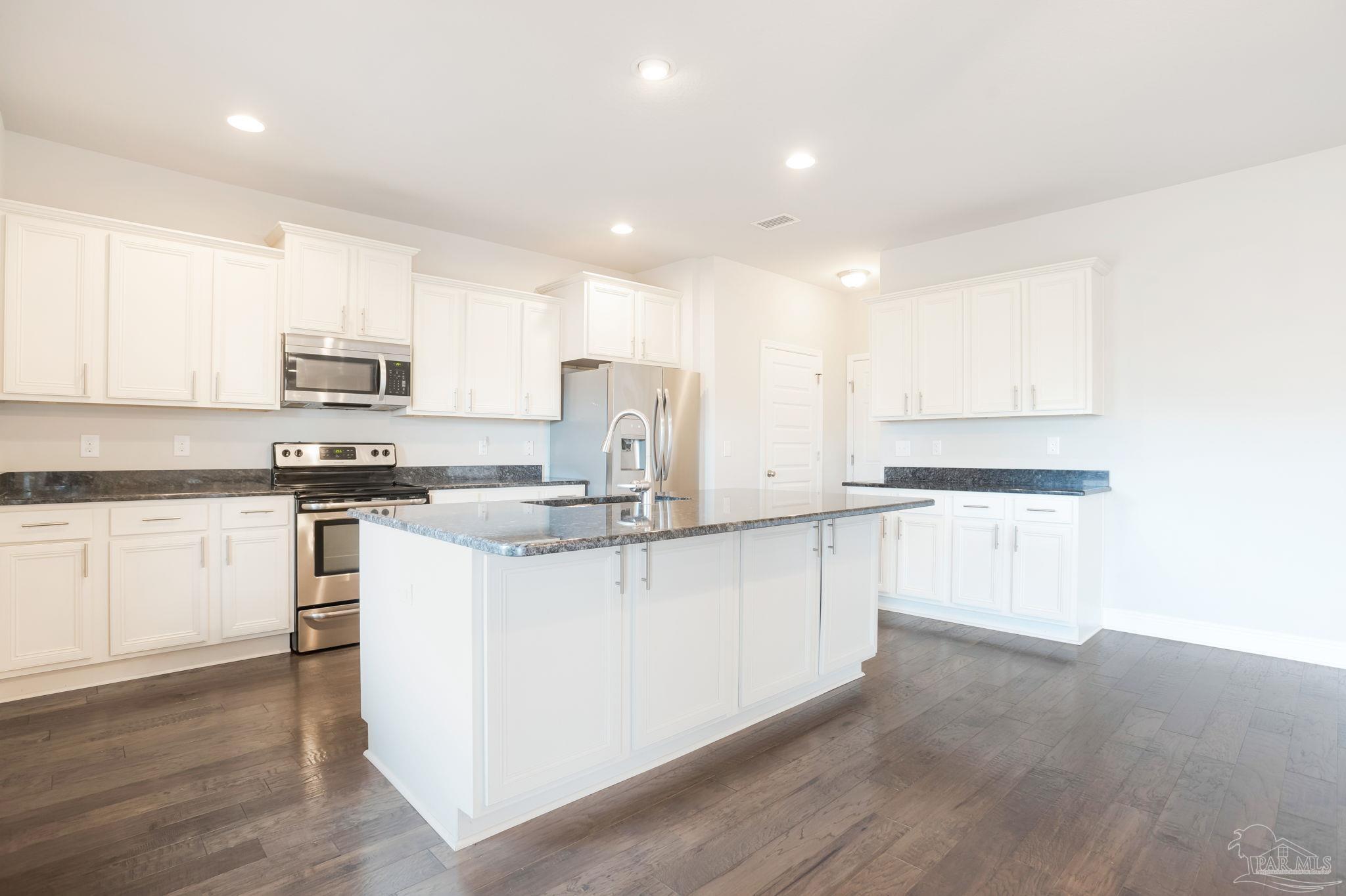 8016 Woodbrook Road Pensacola, FL 32526 - Photo 5 of 52 a kitchen with granite countertop white cabinets and white appliances