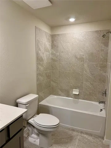 a white toilet and tub sitting next to a bathroom sink