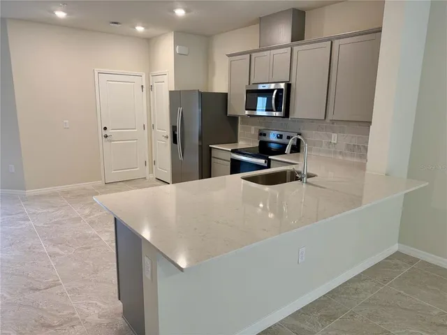 a kitchen with stainless steel appliances a refrigerator sink microwave and cabinets