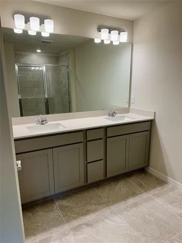 a bathroom with a double vanity sink and a mirror
