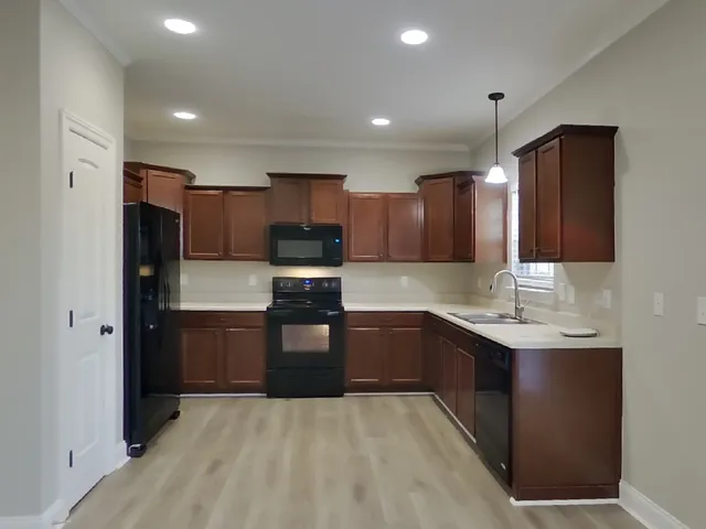 a kitchen with stainless steel appliances granite countertop a sink refrigerator and cabinets