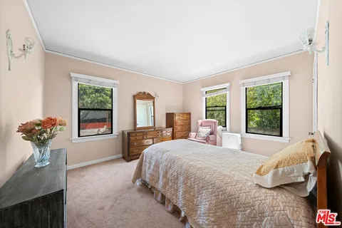 a bedroom with a bed and a large window