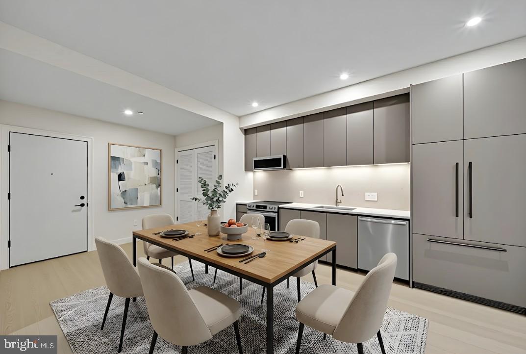 a kitchen with stainless steel appliances a table chairs and a refrigerator