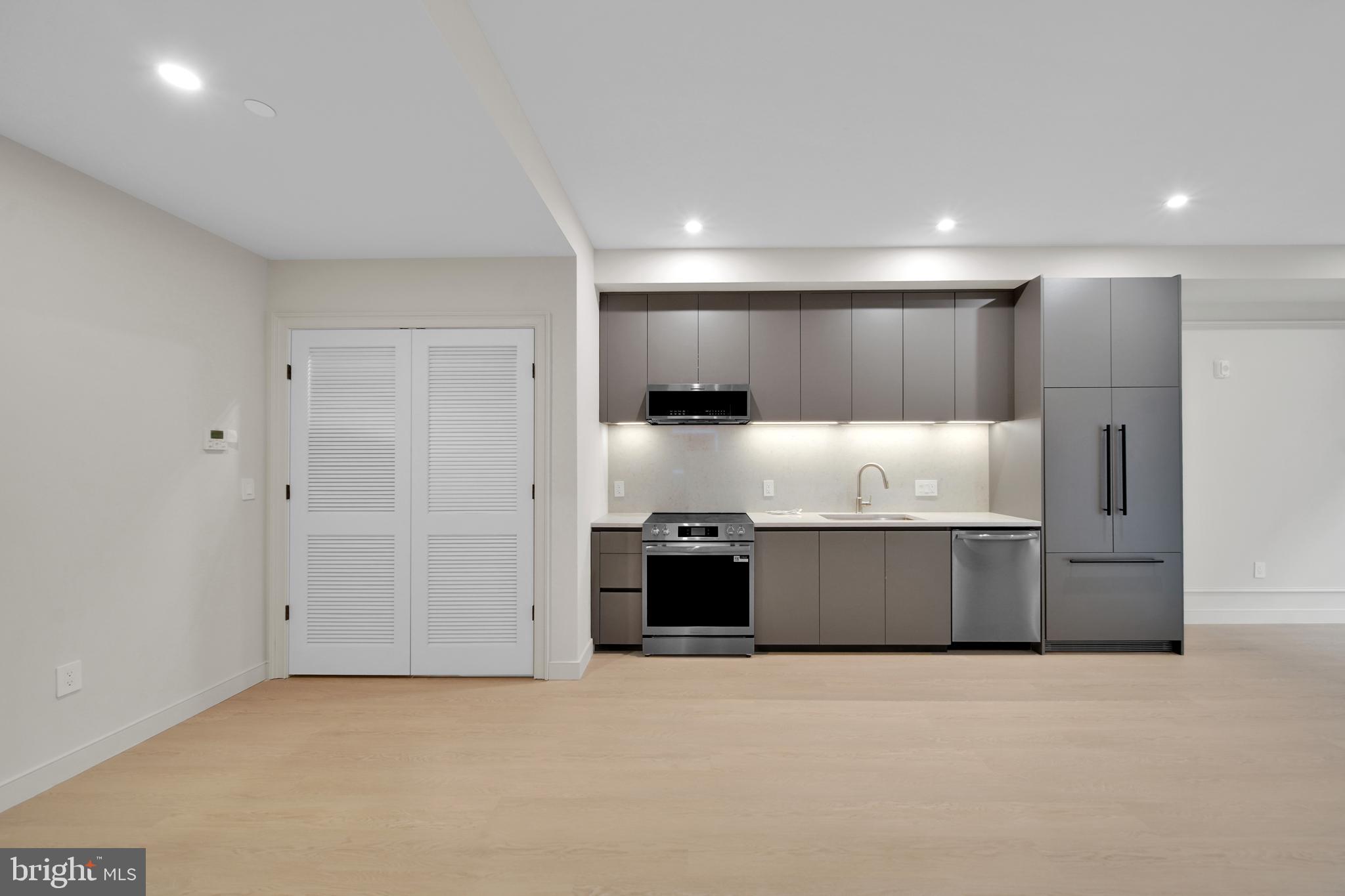 2121 Ward Place Northwest, Unit 402 Washington, DC 20037 - Photo 15 of 21 a large kitchen with a large counter top stainless steel appliances and cabinets