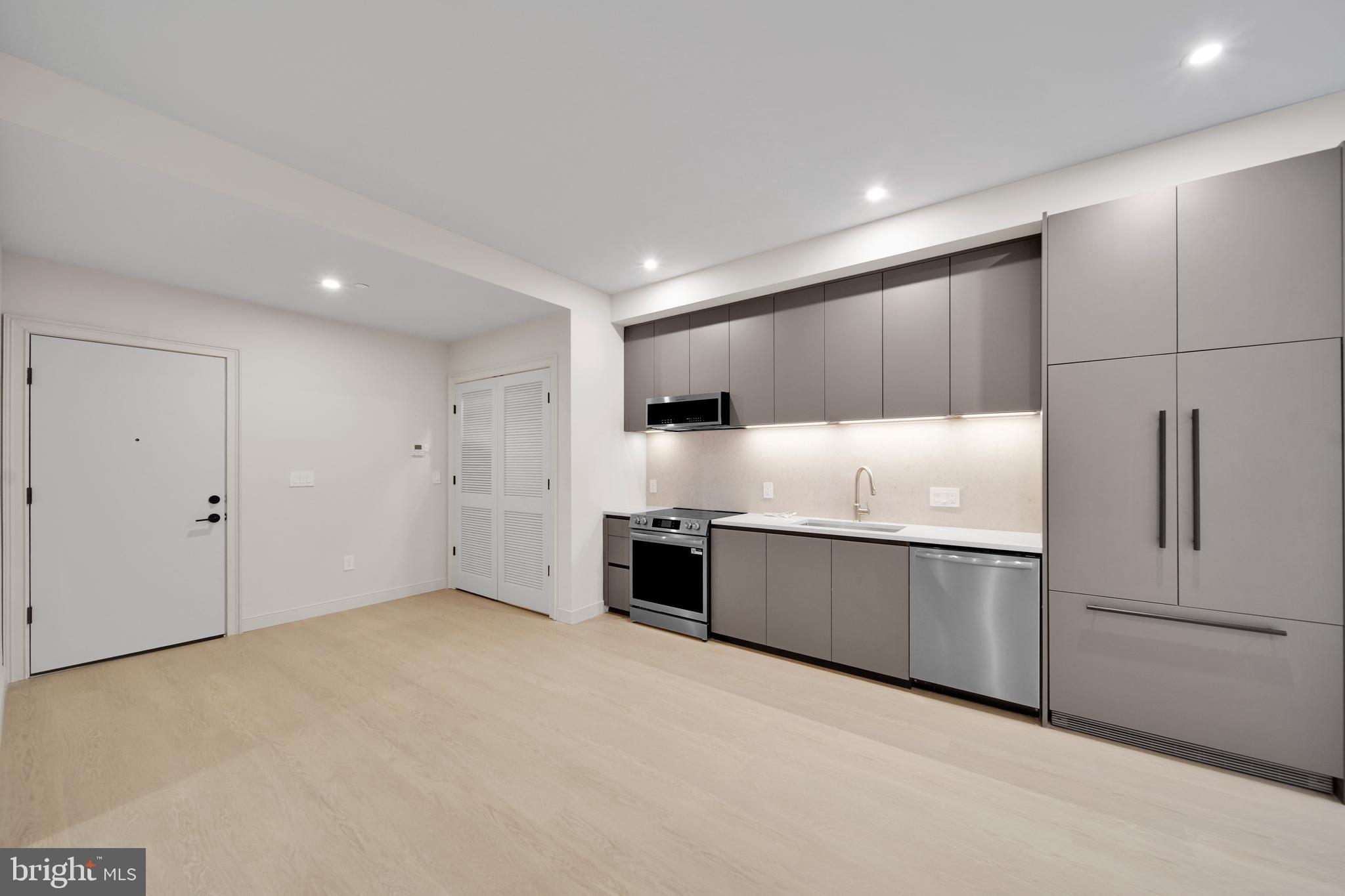 2121 Ward Place Northwest, Unit 402 Washington, DC 20037 - Photo 8 of 21 a large kitchen with stainless steel appliances granite countertop a refrigerator and a sink