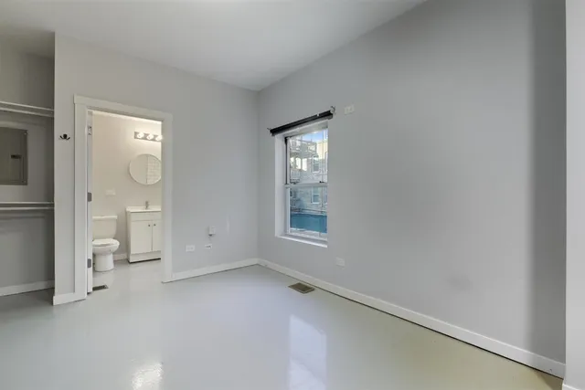 an empty room with mirror and a window