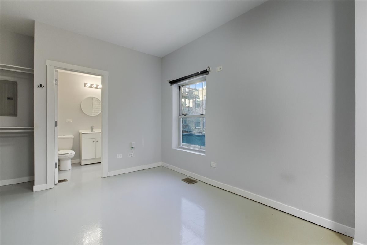 4700 North Racine Avenue, Unit 106 Chicago, IL 60640 - Photo 5 of 10 an empty room with mirror and a window