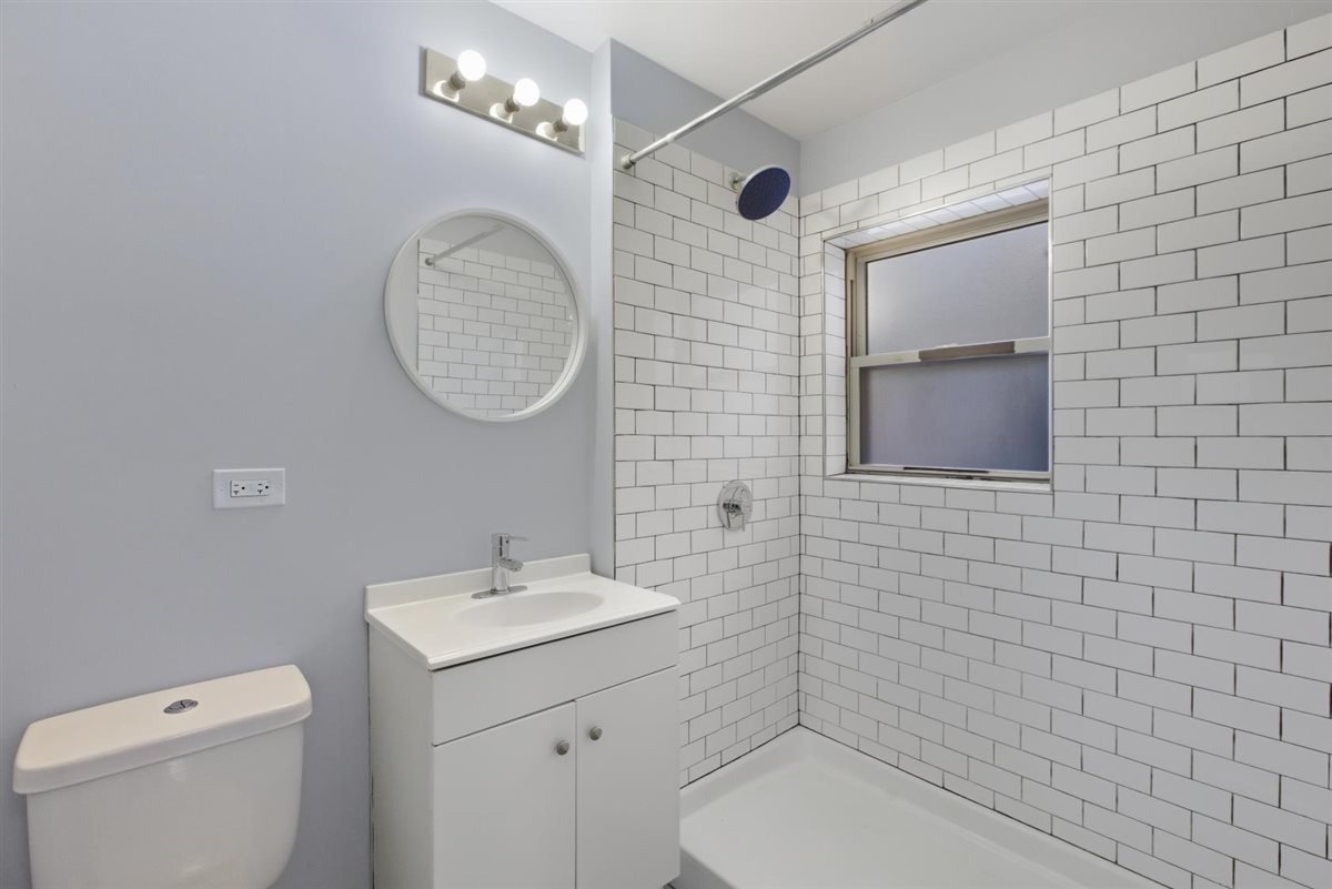 4700 North Racine Avenue, Unit 106 Chicago, IL 60640 - Photo 10 of 10 a bathroom with a toilet a sink and mirror