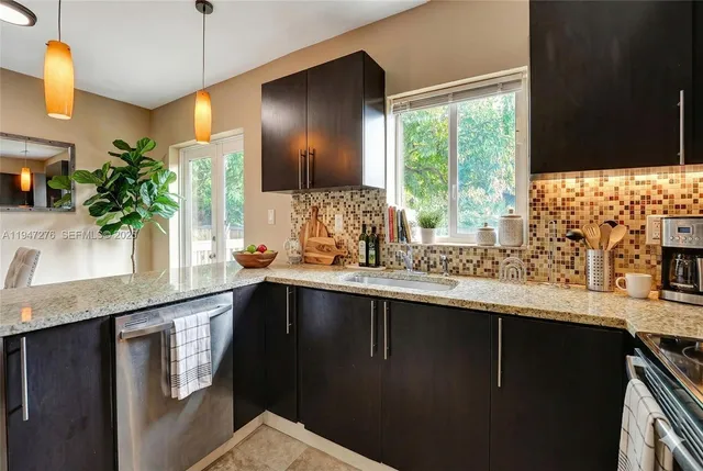 a kitchen with granite countertop a sink a window and potted plant