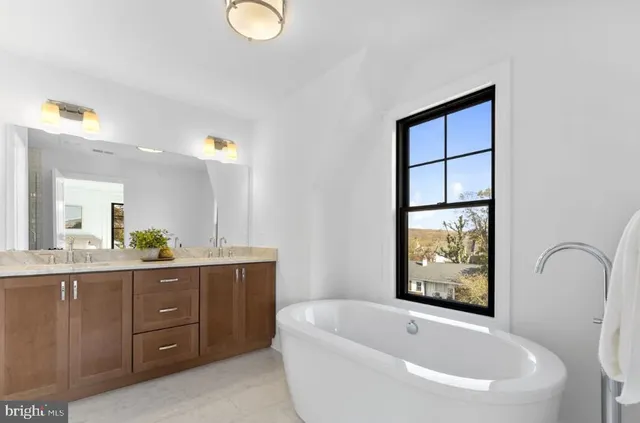a bathroom with a bathtub sink and mirror