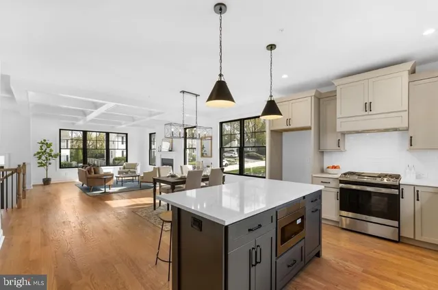 a kitchen with a stove a sink a dining table and chairs