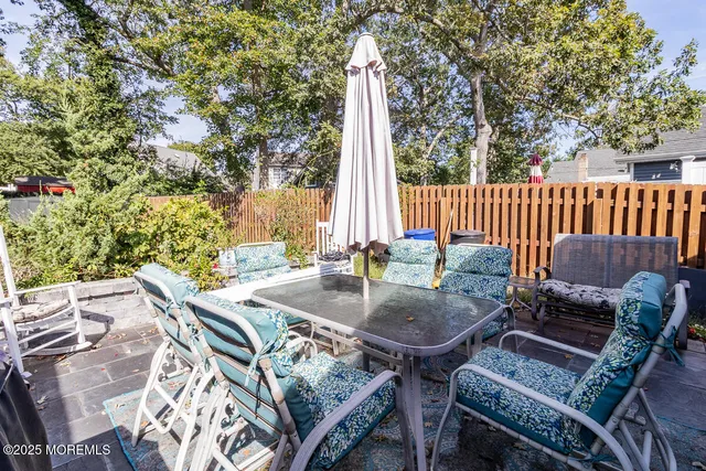 a view of a patio with a table and chairs with wooden fence and floor