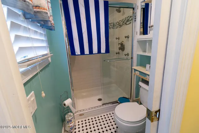 a bathroom with a toilet and a shower