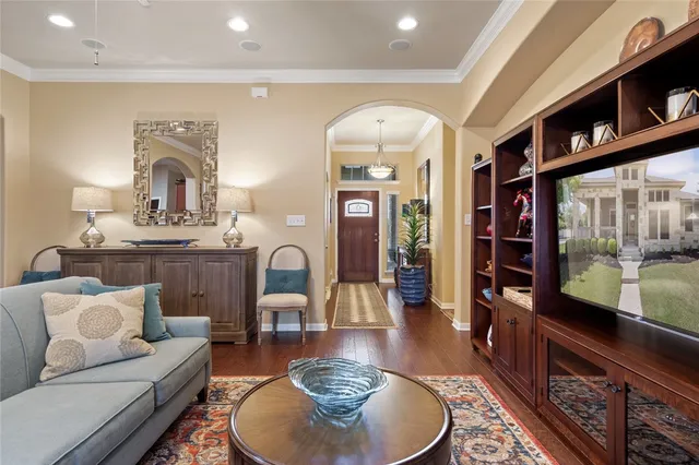 a living room with furniture kitchen view and a wooden floor