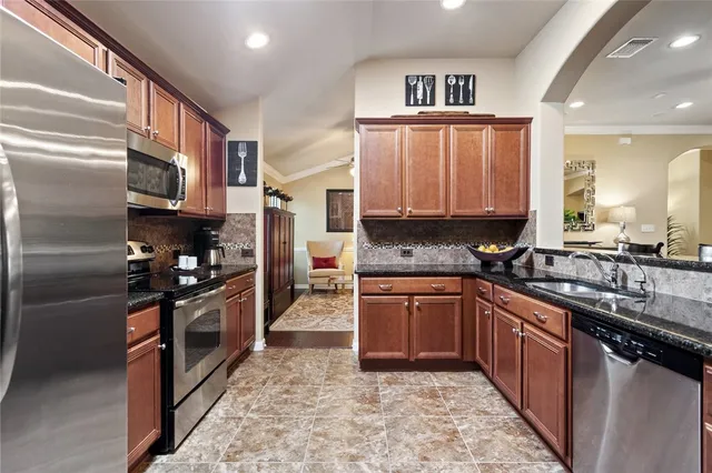 a kitchen with stainless steel appliances granite countertop a refrigerator stove and microwave