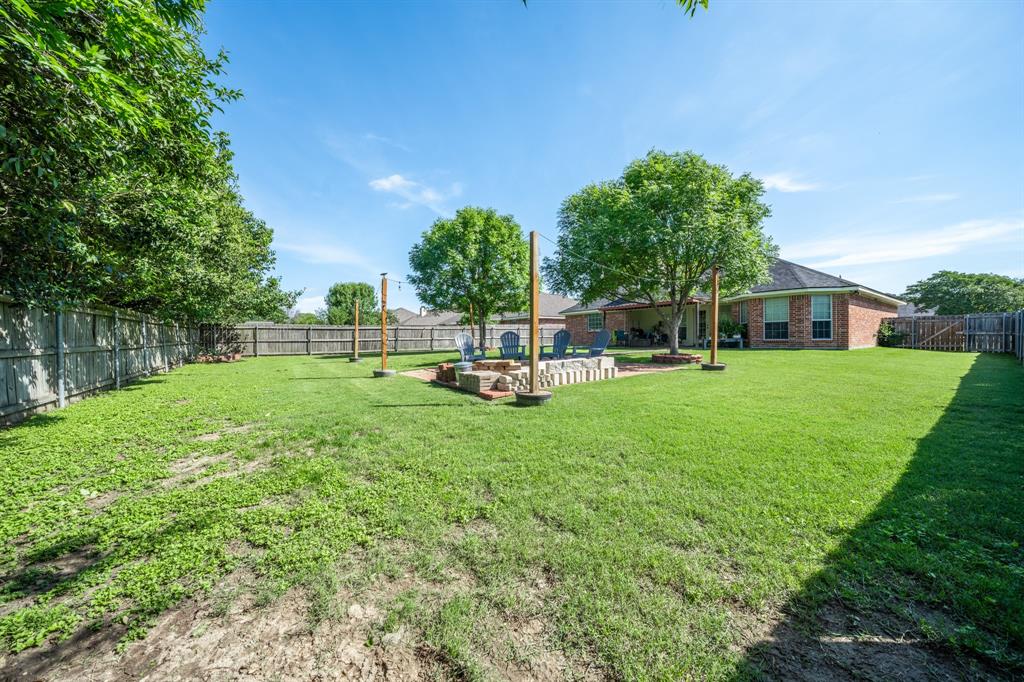10512 Whitney Trace Drive Waco, TX 76708 - Photo 18 of 39 Spacious backyard featuring a manicured lawn, perimeter fencing, and a dedicated fire pit area